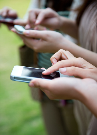 closeup of three people using smart phone.