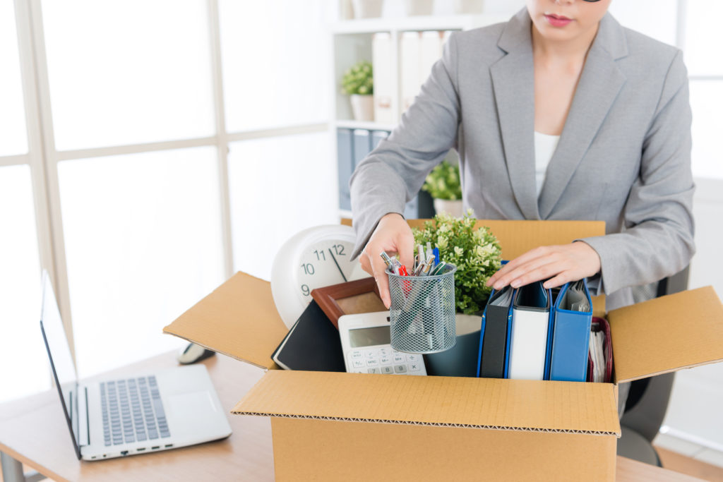 woman packing office supplies into box