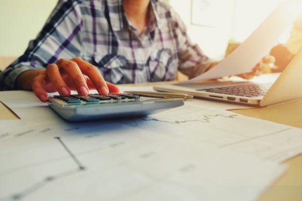 woman using calculator and laptop