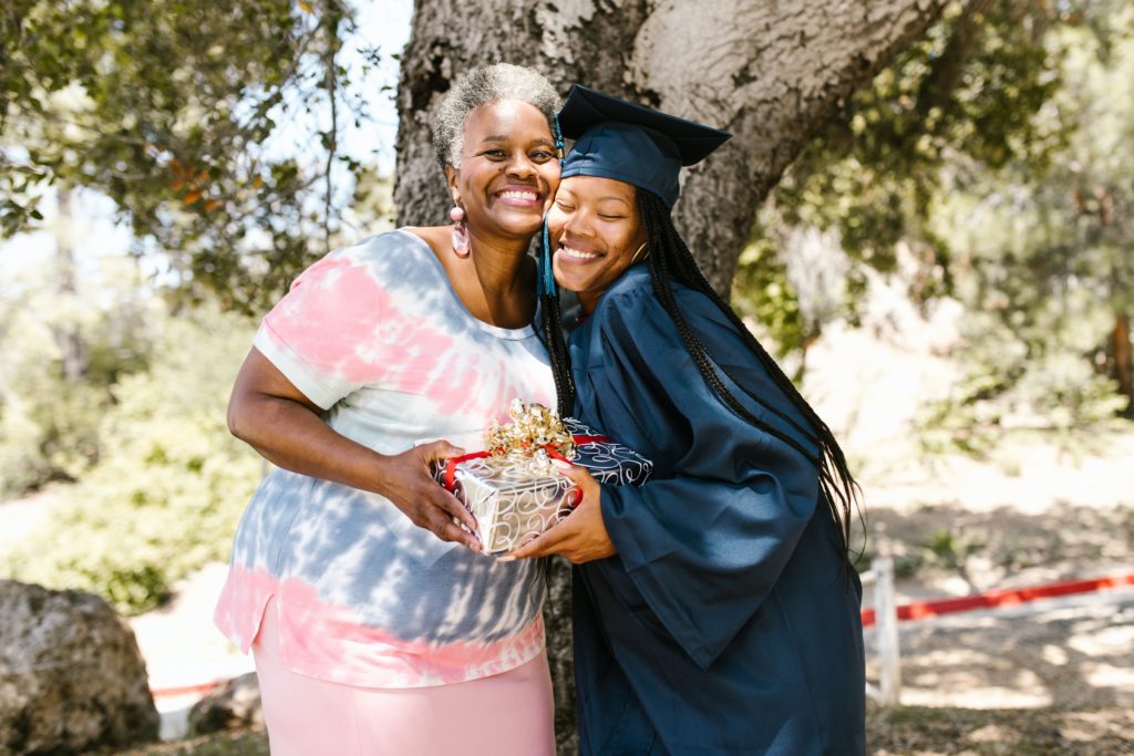 A graduate in a cap in gown with her grandmother